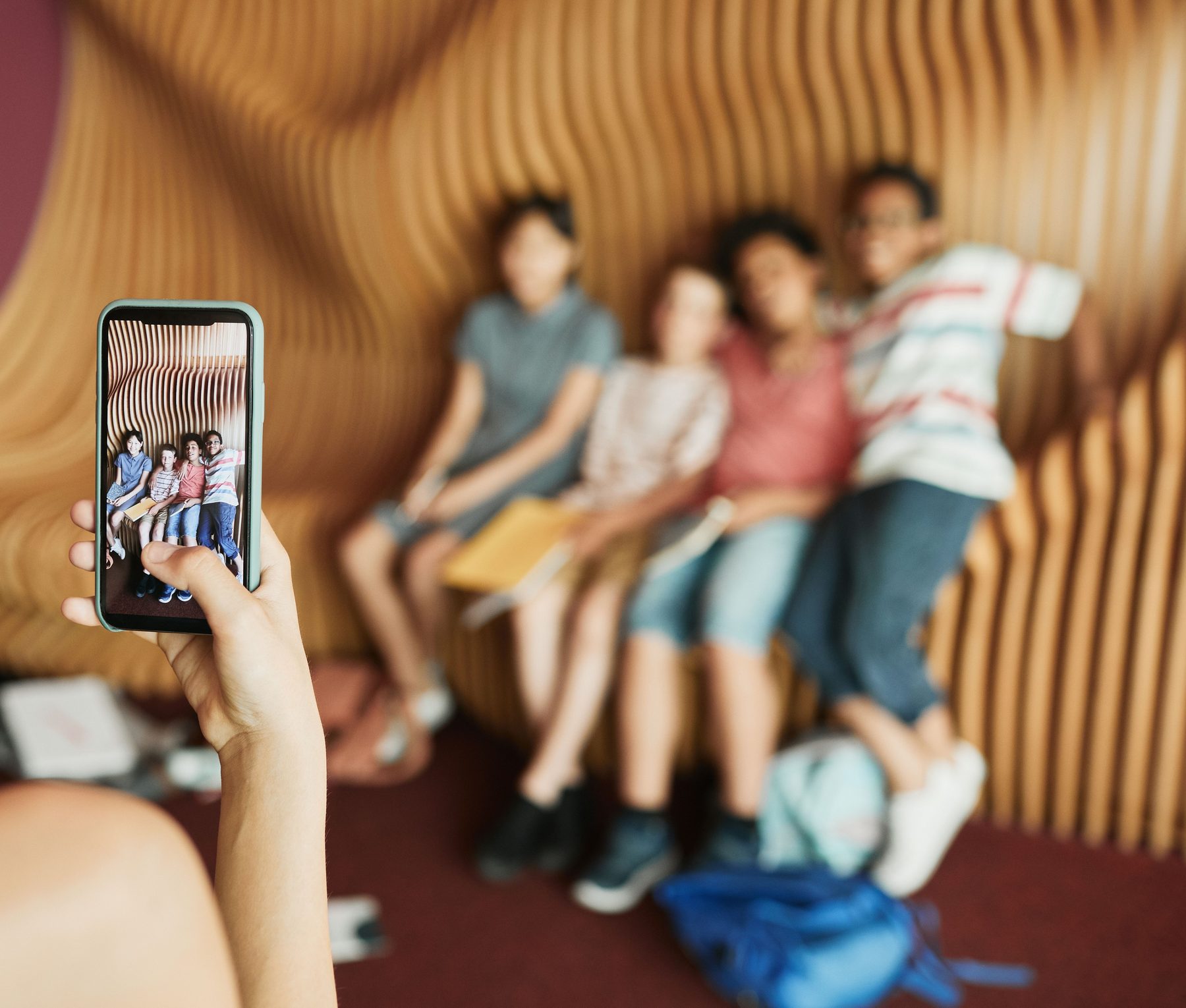 A camp counselor photographing a group of campers on her phone to share with families through myCAMPapp